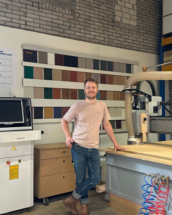 Thomas Galenkamp in de werkplaats van Moderne Ambacht, naast een CNC-machine